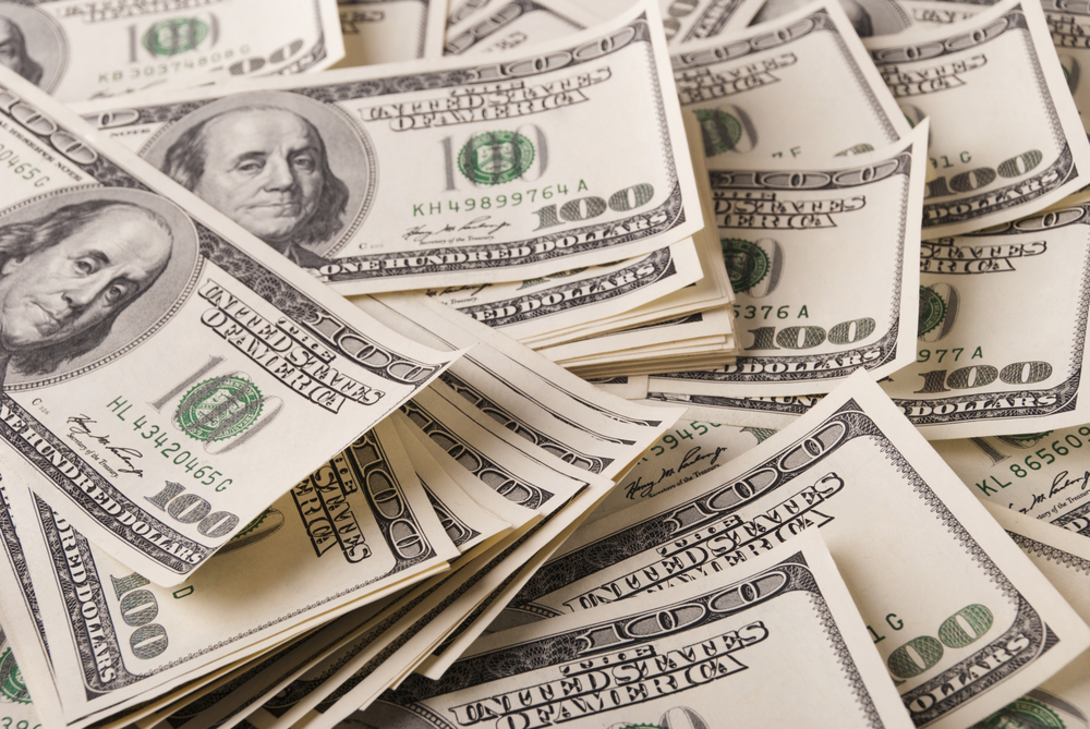 Pile de billets de cent dollars utilisée pour symboliser les économies liées à la formation linguistique en entreprise